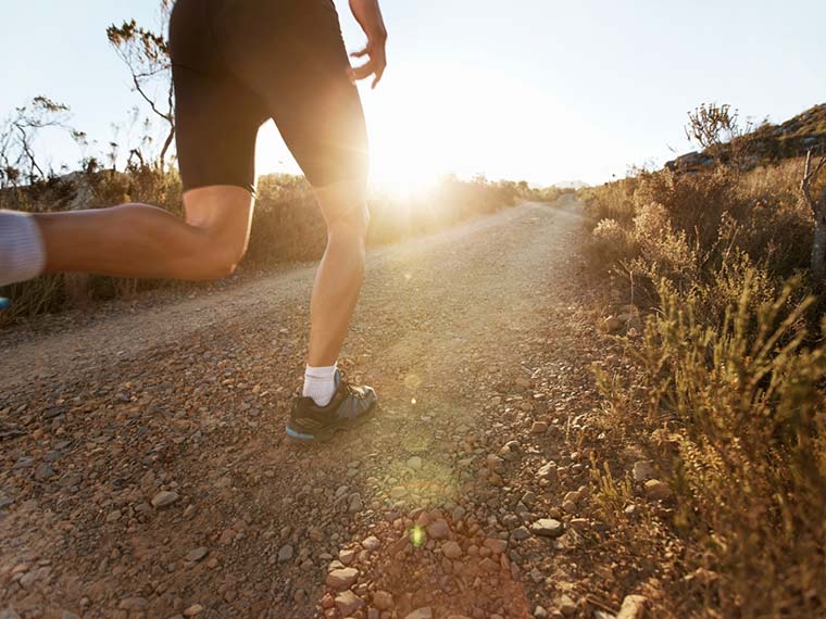 A man jogging down a gravel road